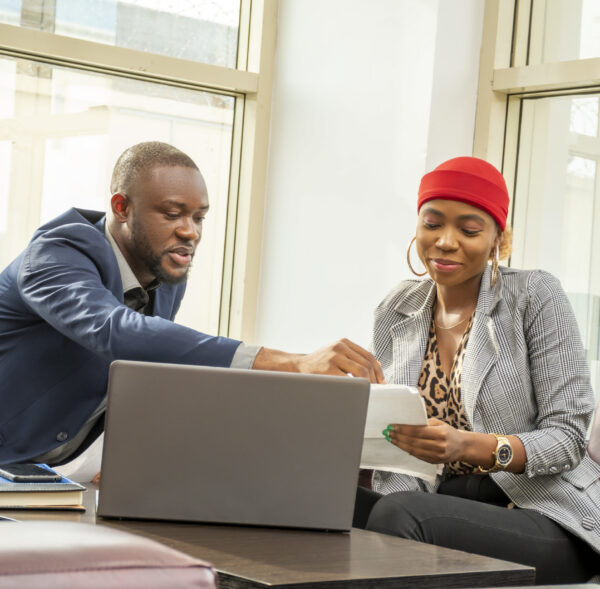 Young black businessman and woman going through some paperwork together