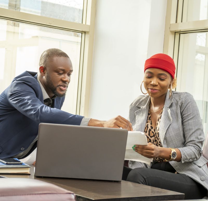 Young black businessman and woman going through some paperwork together Young black businessman and woman going through some paperwork together